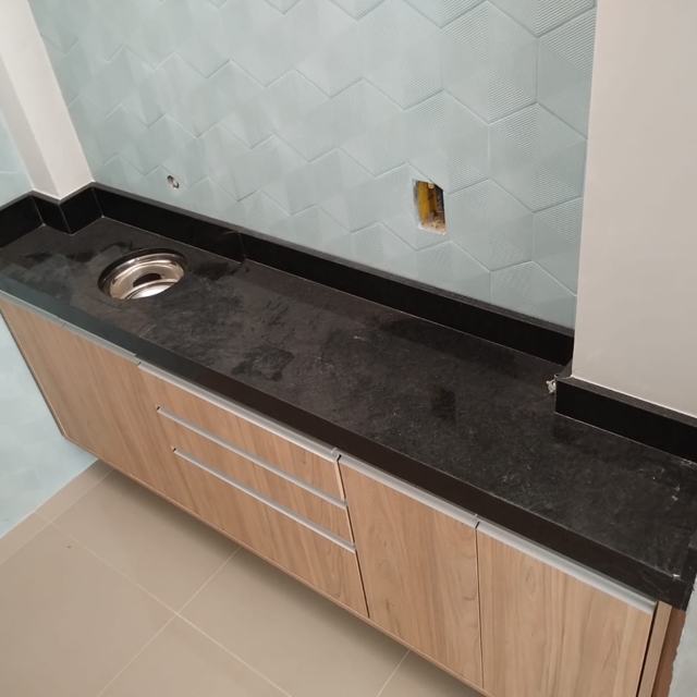Bancada de granito preto sobre armários amadeirados