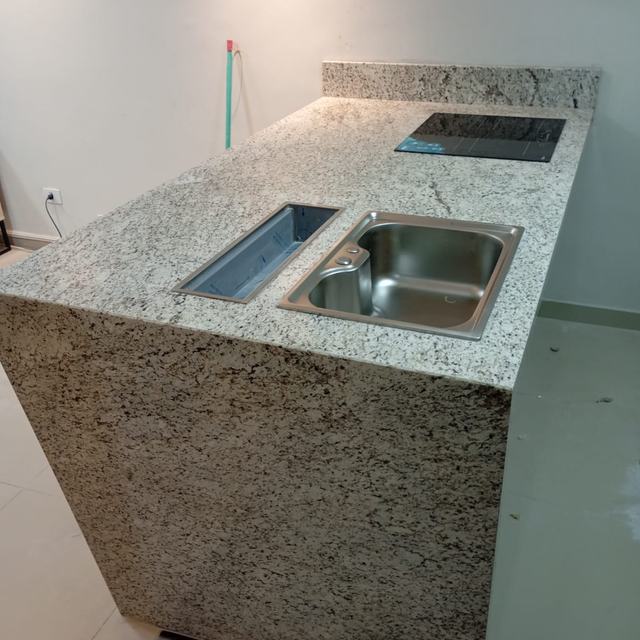 Bancada gourmet de granito claro com cooktop e cuba
