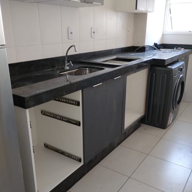 Bancada de cozinha em granito preto com pia e cooktop